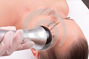 Woman having radio waves lifting face treatment.