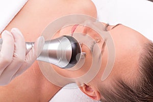 Woman having radio waves lifting face treatment.