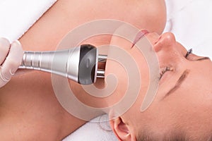 Woman having radio waves lifting face treatment.