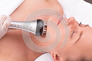 Woman having radio waves lifting face treatment.