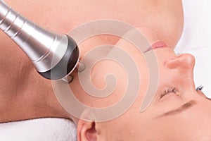 Woman having radio waves lifting face treatment.