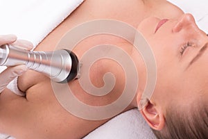 Woman having radio waves lifting face treatment.