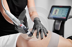 Woman having radiofrequency lifting procedure in cosmetology clinic.