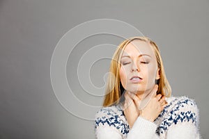 Woman having sore throat feeling pain