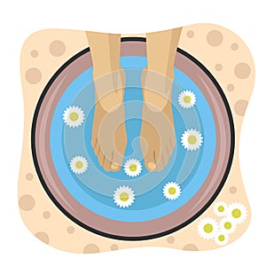 Woman having spa treatments for feet in bowl with water and chamomile