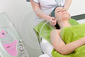 Woman having stimulating facial treatment in spa