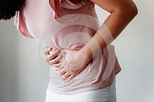 Woman is Having Stomach Ache or Menstrual Period, Close-Up Portrait of Young Woman is Suffering From Abdominal Pain at Her Home. photo