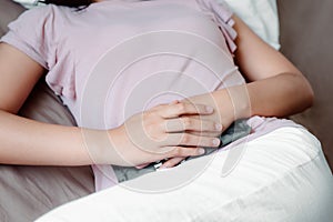 Woman is Having Stomach Ache or Menstrual Period, Close-Up Portrait of Young Woman is Suffering From Abdominal Pain While Resting