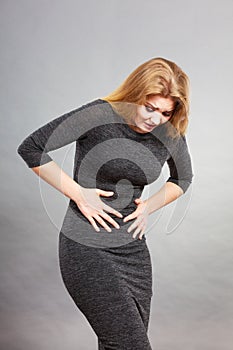 Woman having strong stomach ache. Syndroms photo