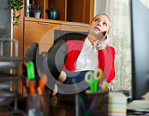 Woman having a tedious time and speaking by mobile photo