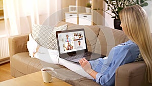 Woman having video chat with her friends on laptop