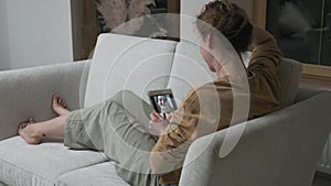 Woman having videocall on smartphone. girl making chat online on phone at home
