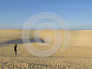 Woman having a walk in the dunes