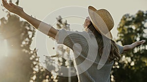 Woman with head back and arms outstretched in nature