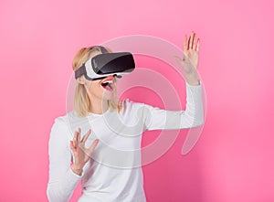 Woman head mounted display pink background. Virtual reality and future technologies. Girl use modern technology vr