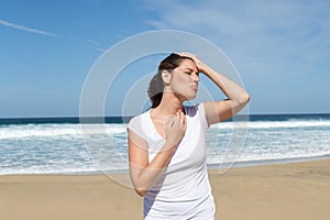 Woman with a headache on the beach