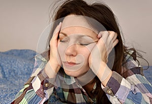Žena bolest hlavy a zavřeno oči ležící dole na její v postel 