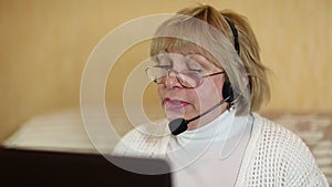Woman with headphones on computer talks to a customer