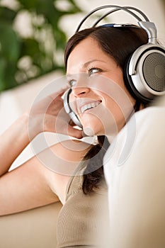 Woman with headphones listen to music in lounge