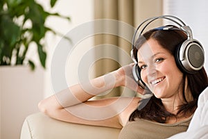 Woman with headphones listen to music in lounge