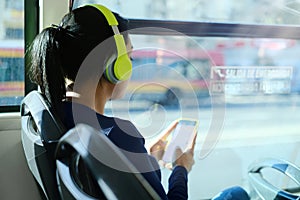 Woman With Headphones Listening To Music Commuting By Bus photo