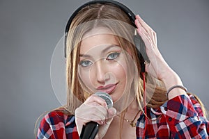Woman with headphones and microphone singing