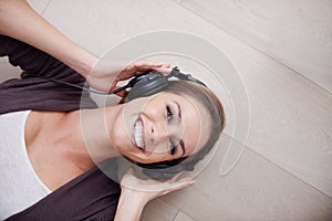 Woman, headphones for music and top view with listening to sound, happiness and relax at home with technology. Podcast