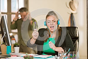 Woman with Headphones Singing Loudly and Annoying Colleague