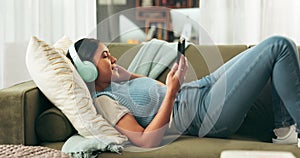 Woman, headphones and smartphone for music with social media, communication and tech for streaming online. Relax on sofa