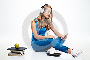 Woman with headphones and using smartphone on the floor