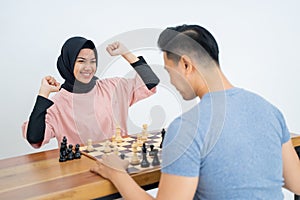 Woman in headscarf with hands clenching victory gesture
