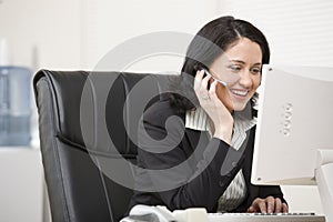 Woman in headset working at computer