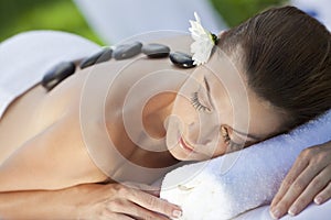 Una mujer sobre el balneario con caliente piedra masaje 