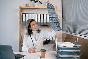 Woman healthcare personnel or doctor looking at body x-ray radiographic image, mri, ct scan in hospital clinic