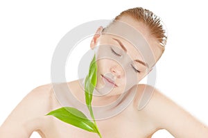 Woman with a healthy complexion holding green leaf.