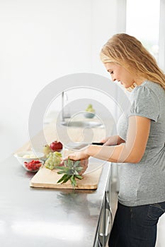 Woman, healthy cooking and fruit for eating food and nutrition for weight loss diet and health at home. Kitchen, cut