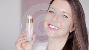 Woman with healthy glowing skin showing natural skincare cosmetic product, face, neck and body cream lotion bottle or