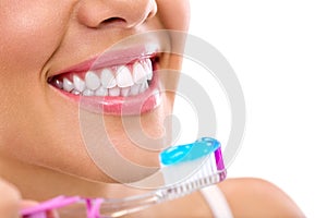 Woman with healthy teeth holding a tooth-brush