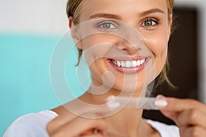 Woman With Healthy White Teeth Using Teeth Whitening Strip