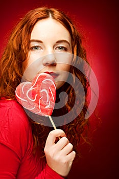 Woman with heart caramel over red background