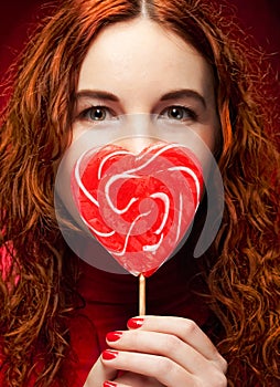 Woman with heart caramel over red background