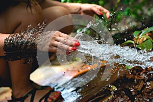 Woman heaving fun with hosepipe splashing water