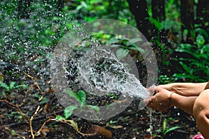 Woman heaving fun with hosepipe splashing water