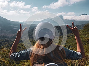 Woman in helmet admire beautiful mountain view in Bali