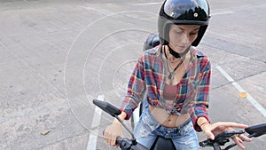Woman with helmet on moped using phone for navigation