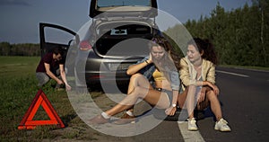 Woman help to man repair broken car