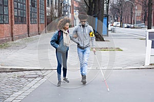 Woman Helping Blind Man While Crossing Road