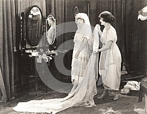 Woman helping bride get dressed