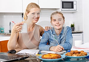 Woman helping daughter to do homework