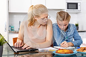 Woman helping daughter to do homework